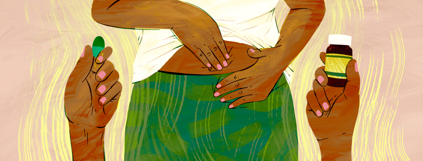 Close up of woman holding stomach with hands holding probiotic bottle and pill