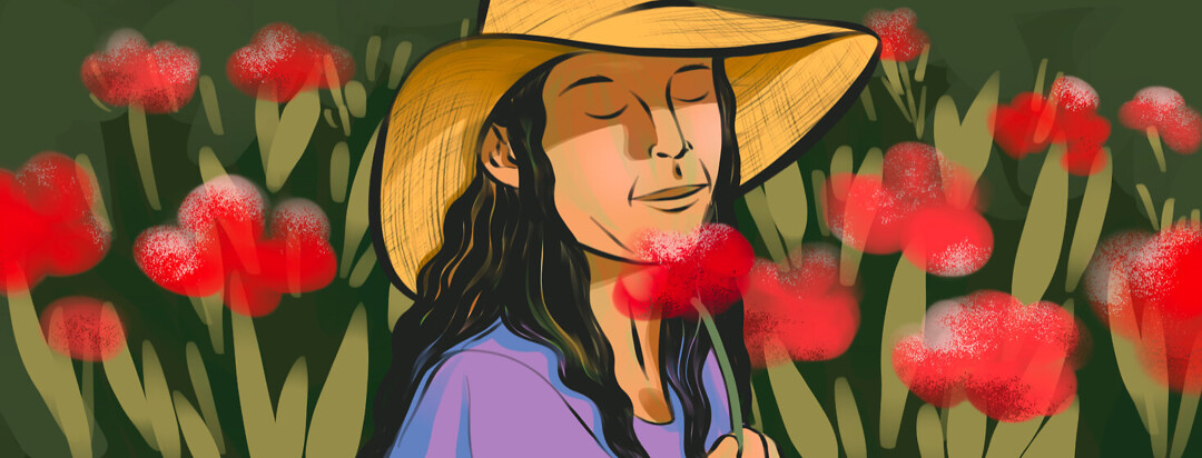 Woman with wide brimmed hat smells a rose in a field of flowers
