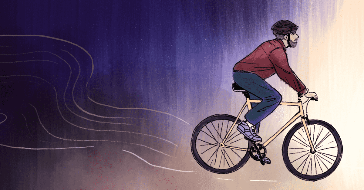 A man rides a bicycle away from the darkness and into the light