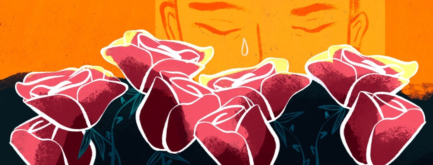A person crying behind a row of roses